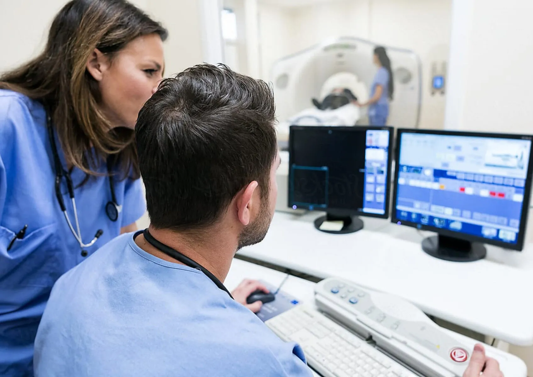 Doctor and CT technologist reviewing medical images.